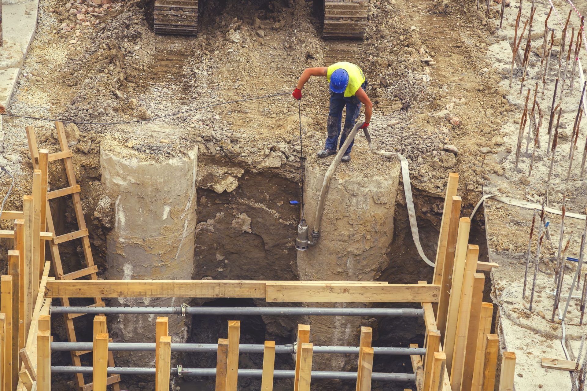 Worker placing water pump to drain trench 2